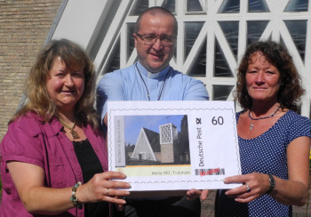 Mit der neuen Briefmarke laden Helga Sperlich, Pfarrer Piotr Pasko OMI und Barbara Meißner zur Quinauer Wallfahrt nach Trutzhain ein. Foto Wolfgang Scholz maria-hilf140625