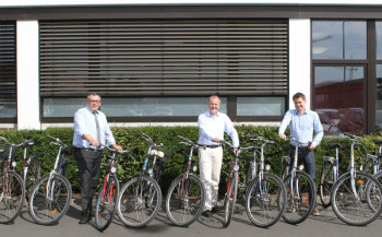 Andreas Siebert, Bürgermeister der Gemeinde Niestetal, nahm die Fahrräder von Fred-Martin Dillenberger, Leiter des Corporate Real Estate Managements und Matthias Schäpers, Referent Nachhaltigkeit bei SMA, entgegen. Foto: nh