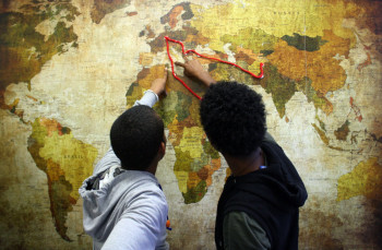 hephZwei Bewohner einer umA-Gruppe der Hephata-Jugendhilfe zeigen auf einer Weltkarte den Weg, auf dem sie aus ihren Heimatländern nach Deutschland geflohen sind. Foto: nh