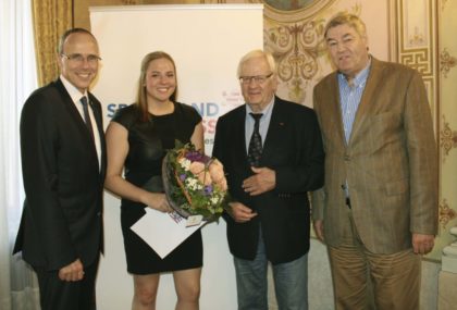 Der hessische Innen-und Sportminister Peter Beuth überreicht das Stipendium an Kirchhofs Handballspielerin Rica Wäscher. Ulrich Manthei und Rolf Müller gratulieren vor Ort. Foto: SG 09 Kirchhof