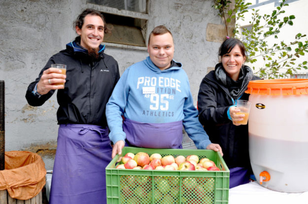 Apfelsaft frisch aus dem Mußer und der Kelter gab es bei (von links) Matthias Dülfer, Tobias Schlienbecher und Catharina Klein-Moddenberg. Foto: Hephata