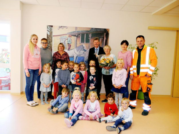 Franziska Gerst, Anne Kahl, Martina Rüdiger-Merz, Bürgermeister Klemens Olbrich, Kindergartenleiterin Heidi Gischler, Edith Götz und Bauhofmitarbeiter Viktor Becker (v.li.) mit einigen Kindern im neuen Kindergarten „Villa Kunterbunt“. Foto: nh