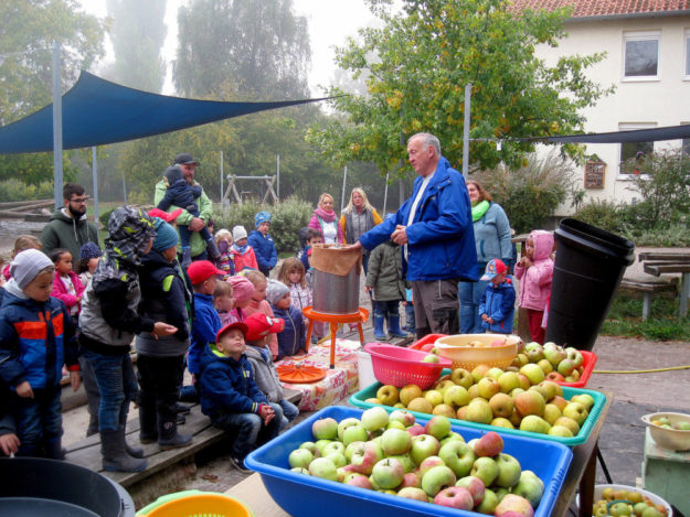 Rainer Hartmann vom NABU (re.) erklärt die Apfelsaftherstellung erst Schritt für Schritt, dann geht es in die Produktion. Foto: nh