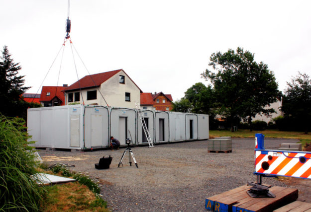 Mit einem Kran werden die 19 Container der provisorischen Kita in der Fritzlarer Straße auf den Platz gehoben. Foto: nh