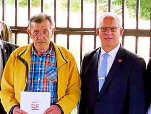 Wolfgang Schütz bekam von Erstem Kreisbeigeordneten Jürgen Kaufmann den Ehrenbrief überreicht. Foto: nh