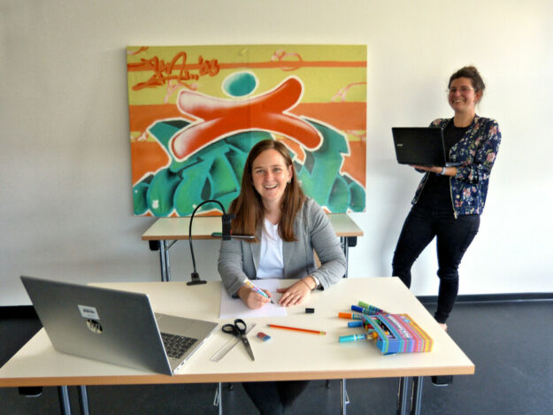 Anika Wolf von der Volkshochschule (re.) und Julia Grunewald-Discher (li.) von der Jugendförderung testen Setup und Technik für das Online-Ferienprogramm. Foto: Jugendförderung des Schwalm-Eder-Kreises