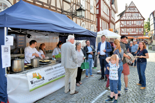 : Bürger*innen und der Magistrat mit Bürgermeister Dr. Nico Ritz (Mitte) freuen sich über das Angebot der Markt*Küche. Foto u. Text: Uwe Dittmer