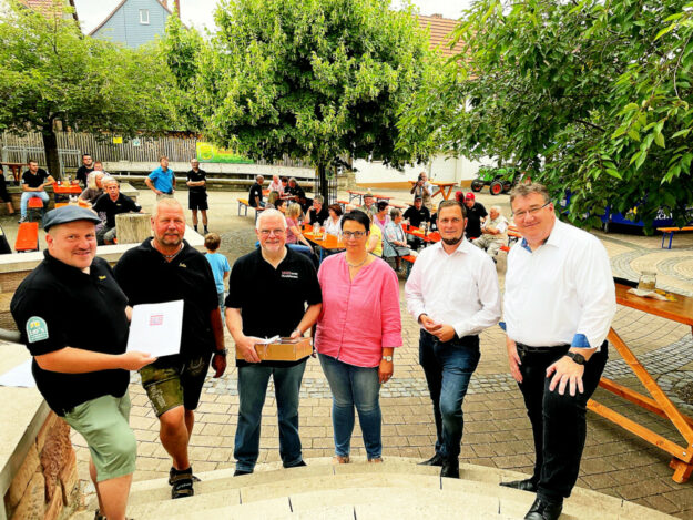 Schlepperfreunde (v.li.): Marc Richter, Jürgen Lau, Ortsvorsteher Martin Gombert, Helga Stumpf, Bürgermeister Heiko Manz, Mark Weinmeister. Foto: Hessische Staatskanzlei