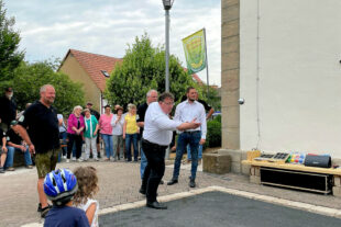 Jetzt möglichst dicht ans „Schweinchen“ treffen. Mark Weinmeister beim Einweihungswurf für die neue Boulebahn in der Ortsmitte. Foto: Hessische Staatskanzlei