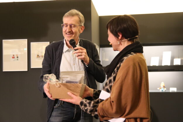 Saskia Wagner überreicht einen Geschenkkorb an Phil Hubbe. Foto: N.N. | Caricatura Galerie