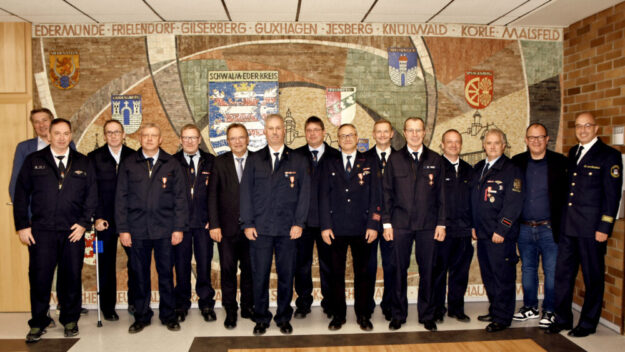 Von links: Bürgemeister Dr. Nico Ritz, stellv. Stadtbrandinspektor Homberg Sascha Harle, Jens Boland, Rainer Freund, Guido Schöneweiß, Landrat Winfried Becker, Peter Ritter, Matthias Knoch, Thomas Wagner, Andreas Keßler, Rainer Keim, stellv. Stadtbrandinspektor Neukirchen Peter Urban, Uwe Mangold, Bürgermeister Marian Knauff, stellv. Kreisbrandinspektor Michael von Bredow. Foto: Christian Rinnert | Kreisverwaltung Schwalm-Eder